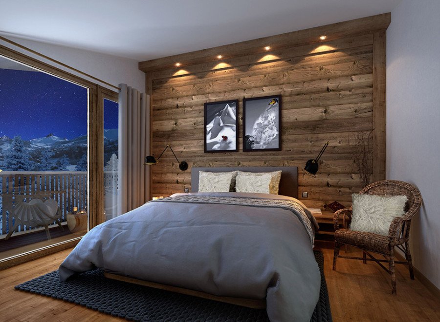 This stunning bedroom boasts a cozy atmosphere with a rustic wooden wall, plush bedding, and a comfortable armchair.