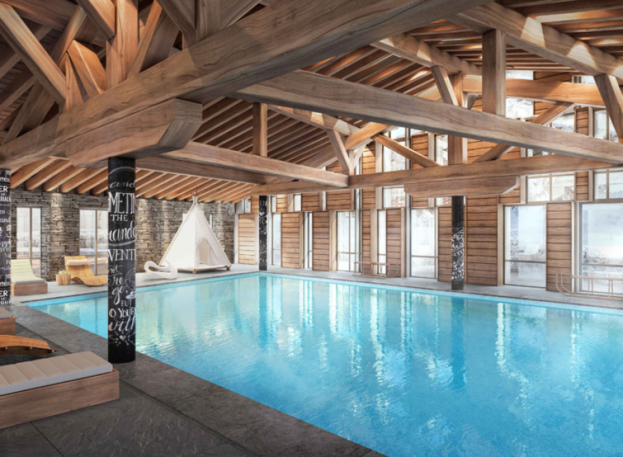 Indulge in luxury at this stunning chalet featuring a spacious indoor pool, surrounded by wooden beams and large windows offering breathtaking views.