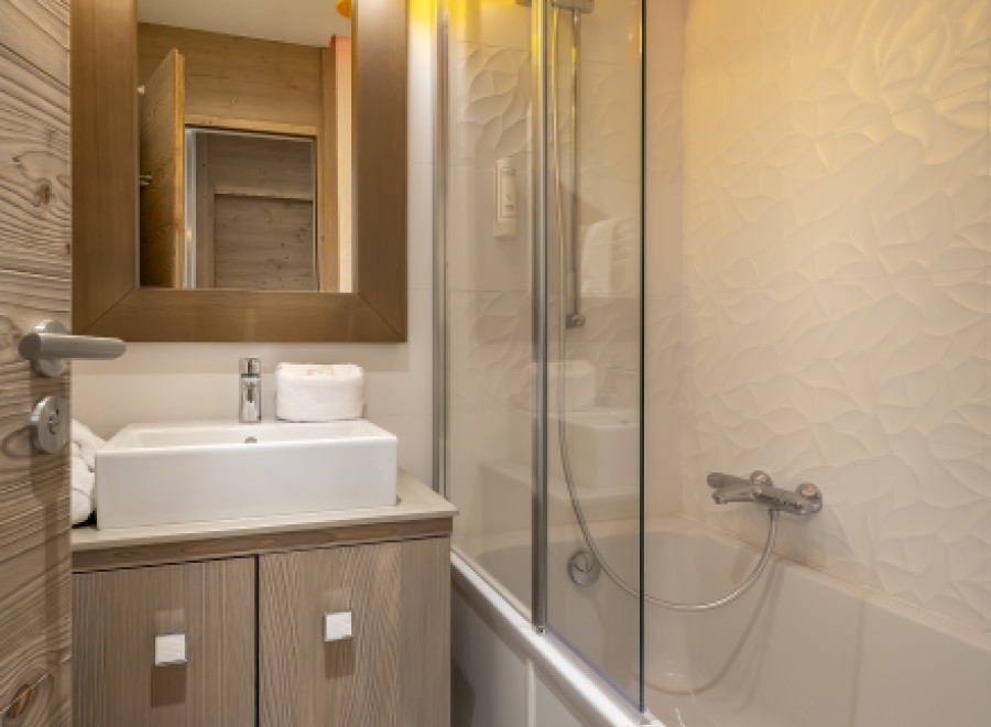 This stunning bathroom boasts a modern design with a sleek glass shower enclosure and a luxurious bathtub.