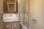 This stunning bathroom boasts a modern design with a sleek glass shower enclosure and a luxurious bathtub.