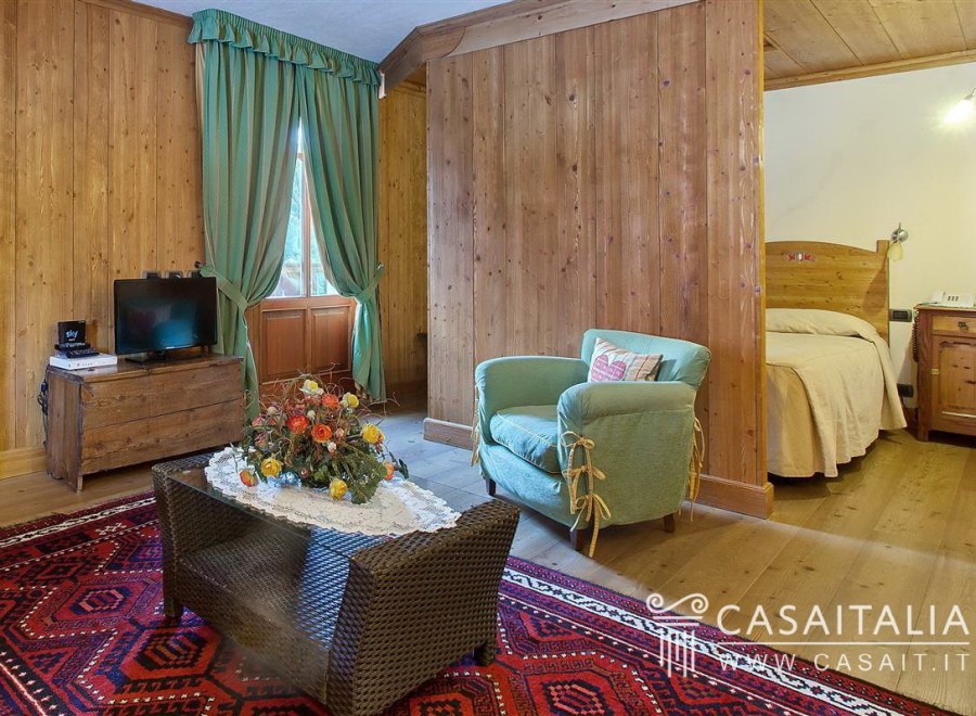 Cozy wooden room with a comfortable armchair and a separate sleeping area.