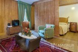 Cozy wooden room with a comfortable armchair and a separate sleeping area.