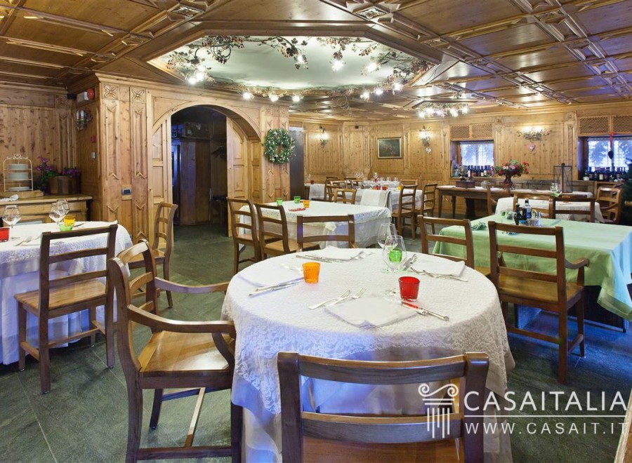 This stunning restaurant boasts a beautiful wooden interior with a coffered ceiling and intricate wood paneling.