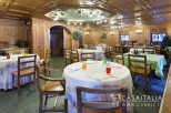 This stunning restaurant boasts a beautiful wooden interior with a coffered ceiling and intricate wood paneling.