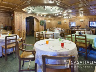 This stunning restaurant boasts a beautiful wooden interior with a coffered ceiling and intricate wood paneling.