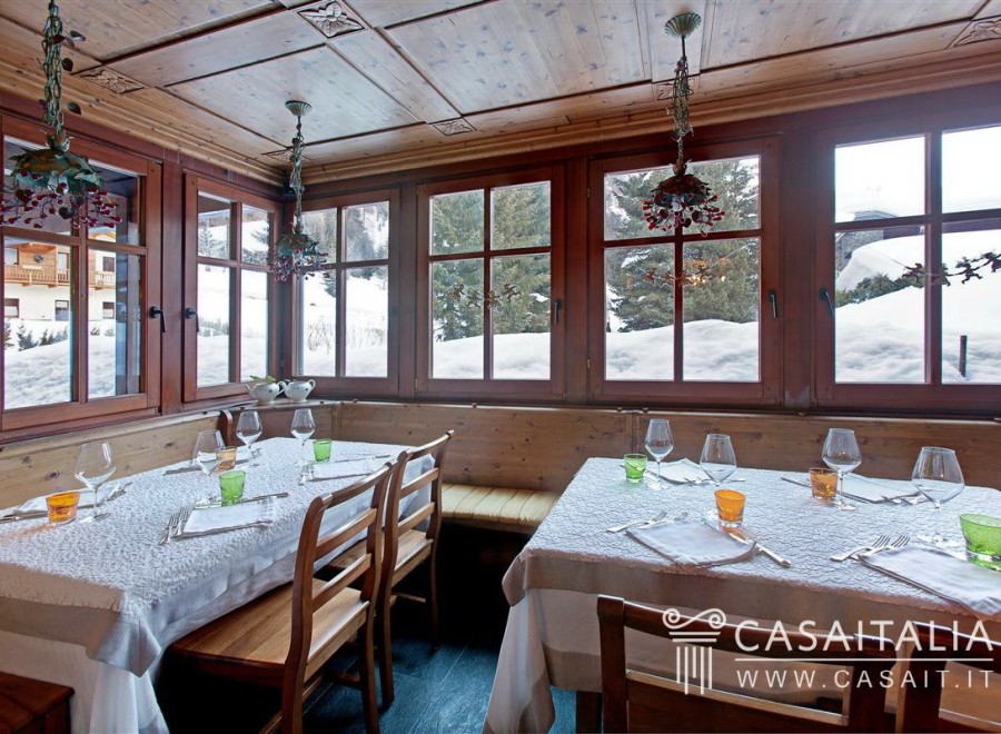 This charming restaurant boasts a rustic-chic ambiance with wooden paneling and large windows offering stunning snowy mountain views.