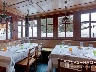 This charming restaurant boasts a rustic-chic ambiance with wooden paneling and large windows offering stunning snowy mountain views.
