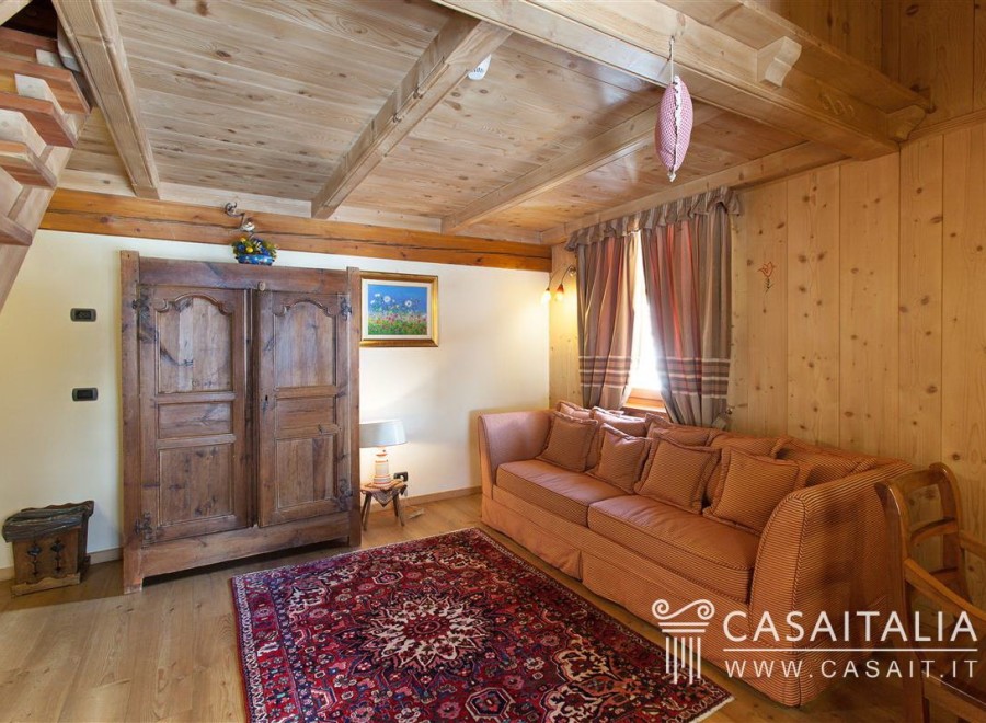Charming wooden chalet with cozy living area featuring a comfortable sofa and antique armoire.
