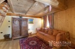Charming wooden chalet with cozy living area featuring a comfortable sofa and antique armoire.