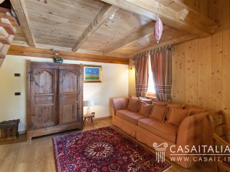 Charming wooden chalet with cozy living area featuring a comfortable sofa and antique armoire.
