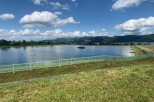 This serene property boasts a picturesque lake with a metal fence, offering stunning views of the mountains in the distance.