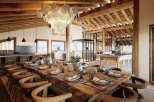 This stunning chalet boasts a spacious open-plan living area with a large wooden dining table perfect for gatherings.