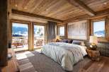 Luxury chalet bedroom with stunning mountain views.