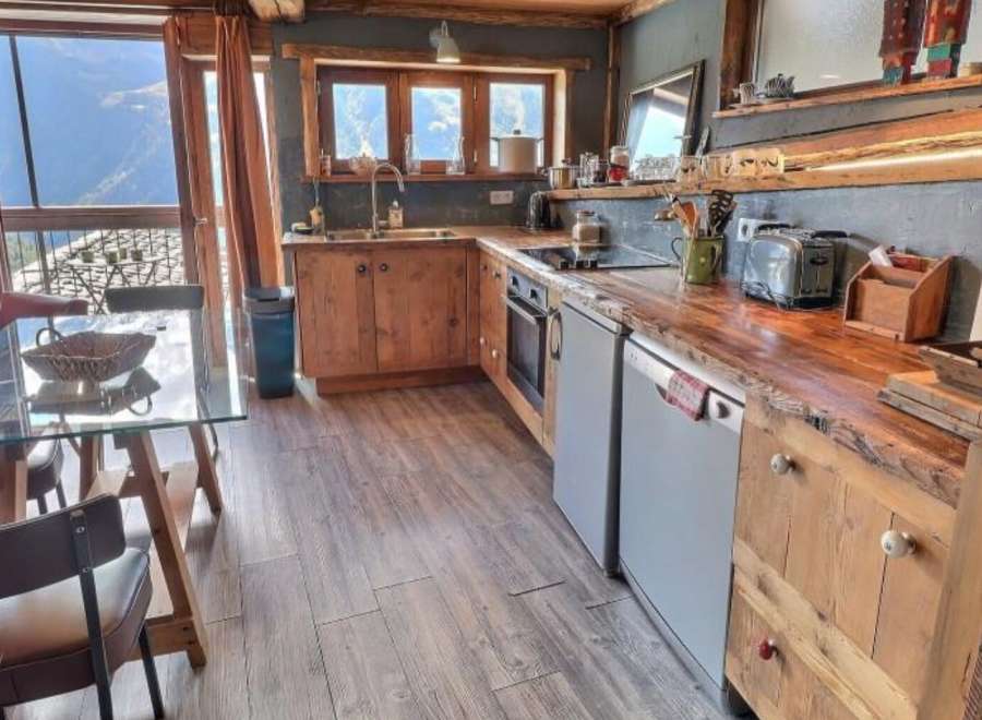 This stunning chalet boasts a rustic-chic kitchen with reclaimed wood countertops and custom cabinetry, offering breathtaking mountain views.