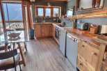 This stunning chalet boasts a rustic-chic kitchen with reclaimed wood countertops and custom cabinetry, offering breathtaking mountain views.