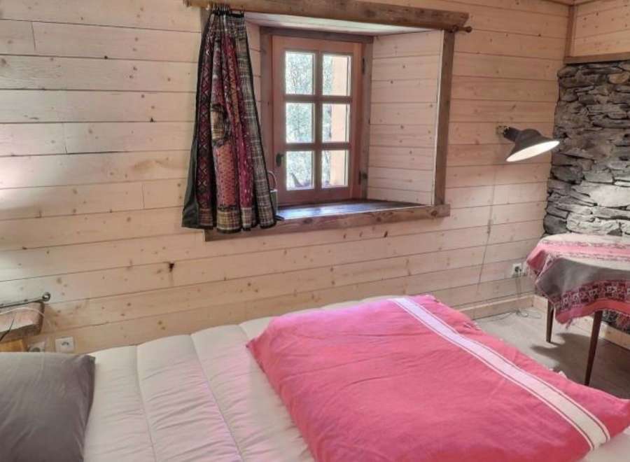Cozy bedroom with wooden walls and stone accents.