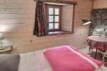 Cozy bedroom with wooden walls and stone accents.