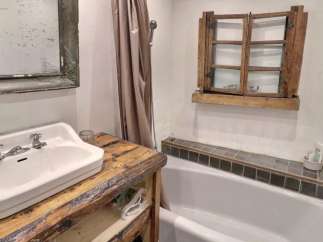Rustic bathroom with vintage sink and wooden vanity.