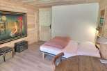 Cozy chalet bedroom with unique artwork, wooden walls, and comfortable bed.