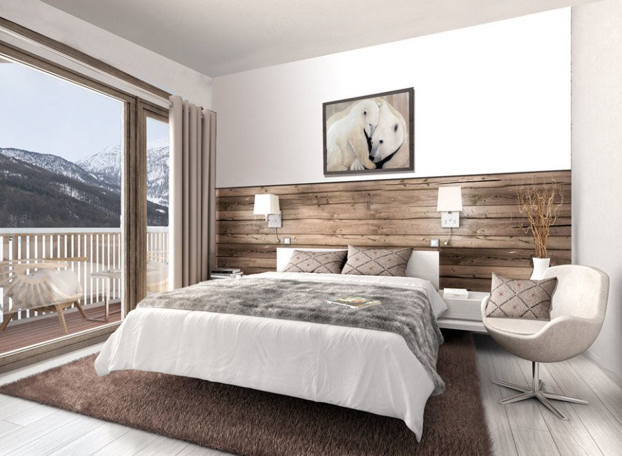 This stunning bedroom boasts a cozy and modern design, featuring a plush bed with a faux fur throw, a rustic wood accent wall, and large windows offering breathtaking mountain views.