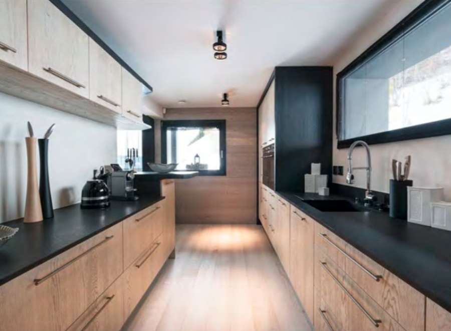 This stunning kitchen boasts a sleek, modern design with light wood cabinets and dark countertops, creating a beautiful contrast.