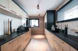This stunning kitchen boasts a sleek, modern design with light wood cabinets and dark countertops, creating a beautiful contrast.