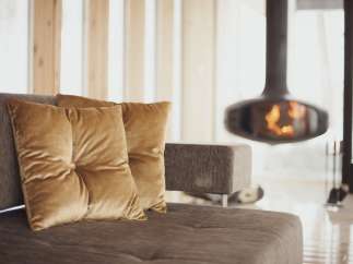 Cozy up by the fireplace in this stunning living room, featuring plush velvet cushions and a modern design.