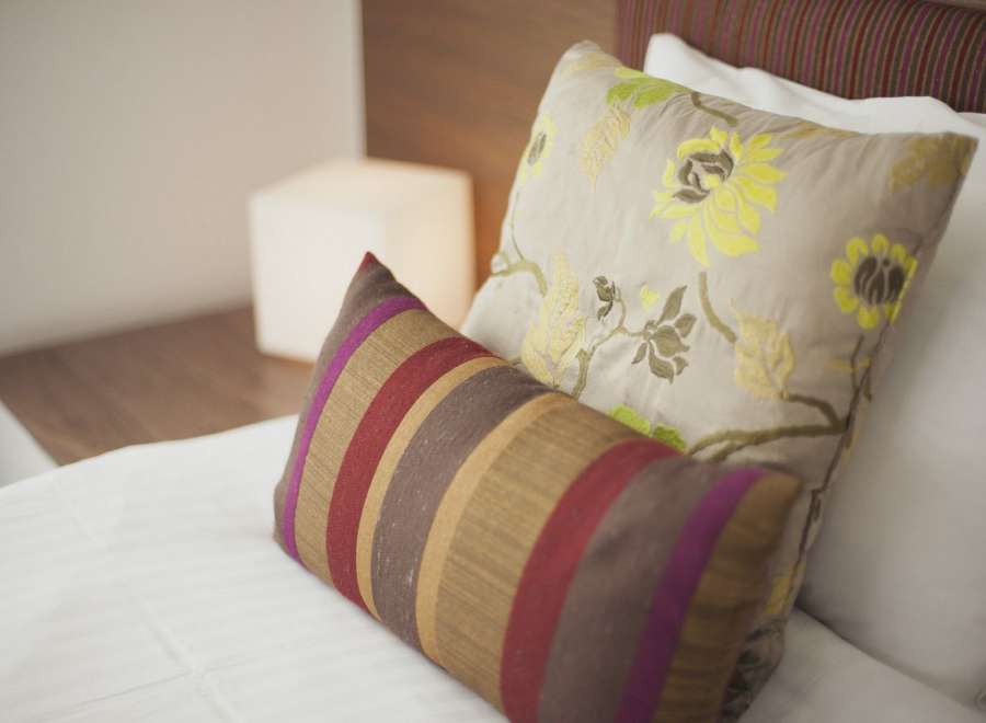 Relax in our comfortable beds, featuring luxurious linens and stylish throw pillows.