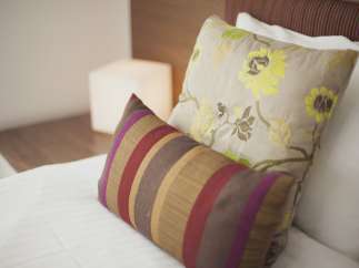 Relax in our comfortable beds, featuring luxurious linens and stylish throw pillows.