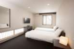 Relax in this bright and airy hotel room, featuring two comfortable twin beds and a flat-screen TV.