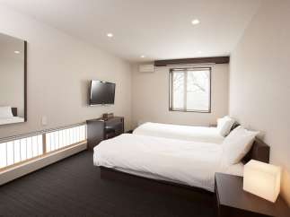 Relax in this bright and airy hotel room, featuring two comfortable twin beds and a flat-screen TV.