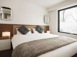 Cozy bedroom with a king-size bed, plush pillows, and a faux fur throw.