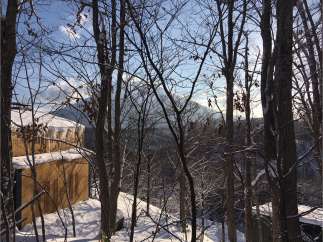 Nestled in a snowy forest, this stunning property offers breathtaking views of majestic mountains.