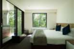 Wake up to stunning views of lush greenery from this luxurious bedroom.