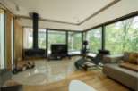 Stunning modern living room with floor-to-ceiling windows showcasing breathtaking forest views.