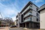 This stunning modern building boasts spacious balconies with glass railings, offering breathtaking views.
