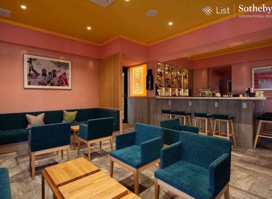 Stylish lounge area with teal armchairs and a comfortable sofa, perfect for relaxing after a day of skiing.