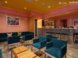Stylish lounge area with teal armchairs and a comfortable sofa, perfect for relaxing after a day of skiing.