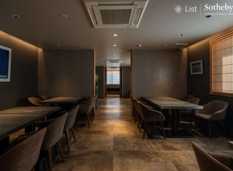 Sophisticated dining space featuring sleek, dark wood tables and comfortable armchairs.