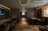 Sophisticated dining space featuring sleek, dark wood tables and comfortable armchairs.