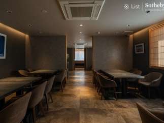 Sophisticated dining space featuring sleek, dark wood tables and comfortable armchairs.