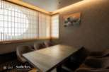 This exquisite dining room boasts a serene ambiance, highlighted by traditional shoji screens and a stunning Great Wave print.