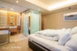 Luxurious bedroom with ensuite bathroom featuring a freestanding bathtub and glass shower enclosure.