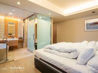 Luxurious bedroom with ensuite bathroom featuring a freestanding bathtub and glass shower enclosure.