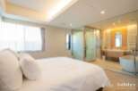Luxurious bedroom with ensuite bathroom featuring a freestanding bathtub and glass enclosure.