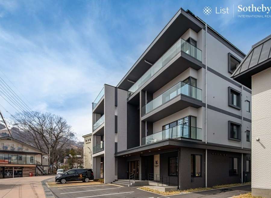 This stunning modern building boasts spacious balconies with glass railings, offering breathtaking views.