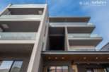 This stunning modern building boasts sleek architecture and multiple balconies, offering residents breathtaking views and ample outdoor space.