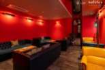 Luxurious red-walled lounge with plush leather sofas and armchairs, perfect for relaxing and socializing.