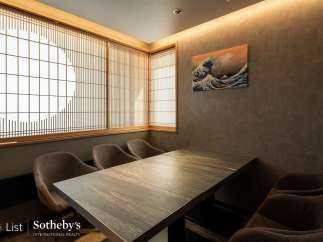 This exquisite dining room boasts a serene ambiance, highlighted by traditional shoji screens and a stunning Great Wave print.