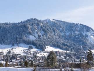 Nestled in a picturesque Swiss village, this stunning property offers breathtaking views of snow-capped mountains and a charming winter landscape.